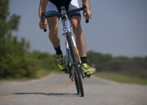 Cyclist riding a mountain bike on a scenic road in Cozumel Mexico, near Stingray Villa vacation rental, ideal for outdoor adventures and exploring the beautiful island environment.