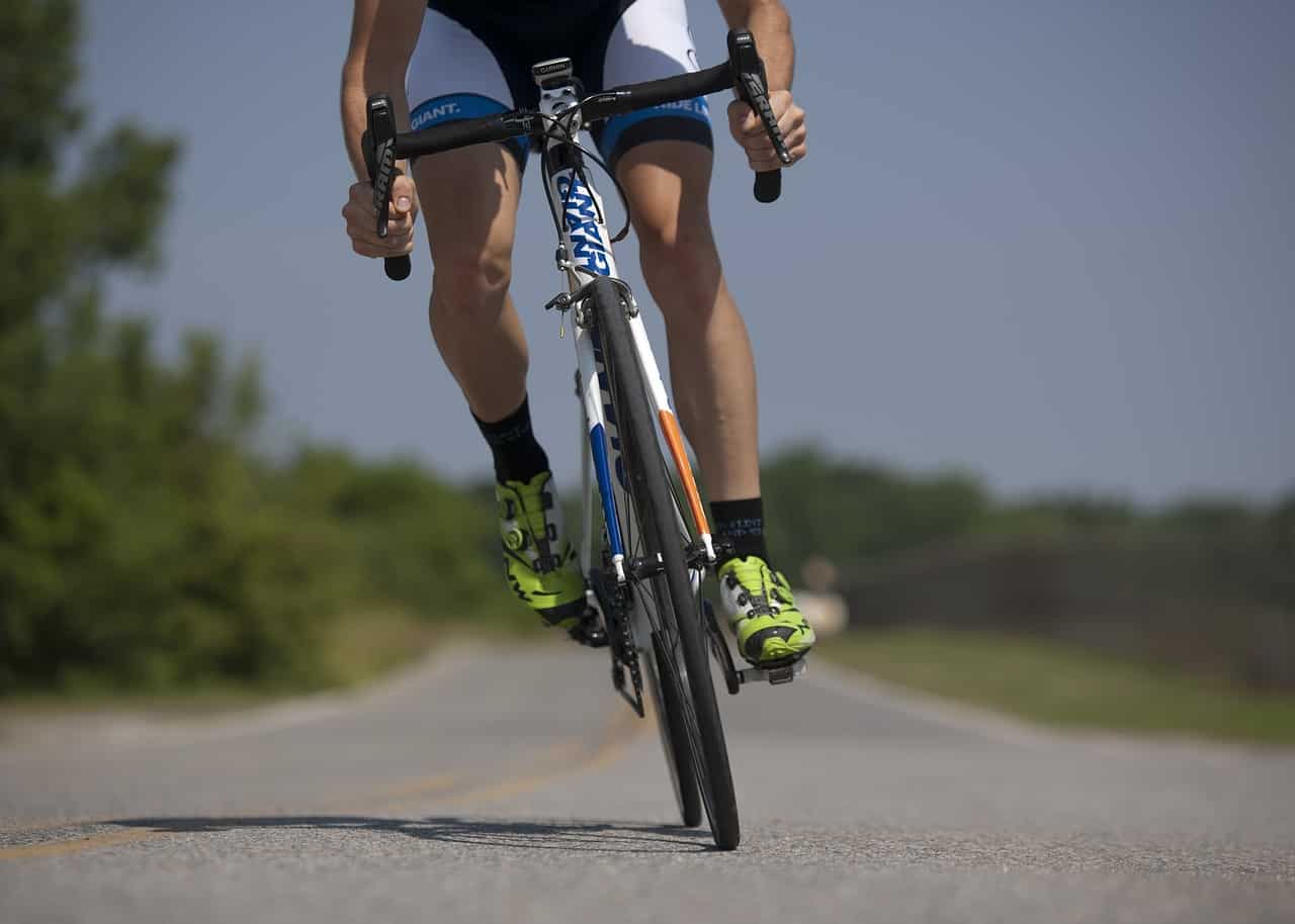 Cyclist riding a mountain bike on a scenic road in Cozumel Mexico, near Stingray Villa vacation rental, ideal for outdoor adventures and exploring the beautiful island environment.