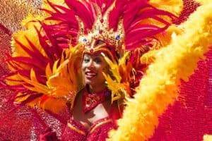 Red and yellow carnival costume featuring feathers, sequins, and beaded accessories for vibrant festival celebrations.