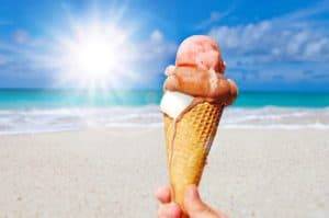 Soft-serve ice cream cone with strawberry and vanilla flavors on Cozumel beach, Mexico, under sunny sky, related to vacation fun and tropical getaways at Stingray Villa.