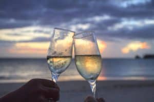 Relaxing sunset scene at Stingray Villa in Cozumel, Mexico, with two glasses of champagne celebrating vacation moments by the beach. Perfect for romantic getaways and coastal luxury.