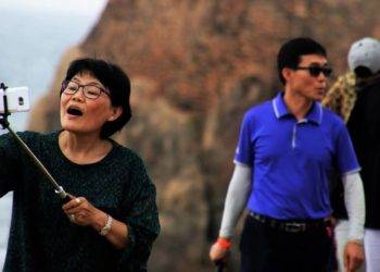 Vaccine-rich traveler taking selfies at Cozumel beach near Stingray Villa vacation rental in Mexico. Perfect destination for a luxurious getaway with scenic ocean views.