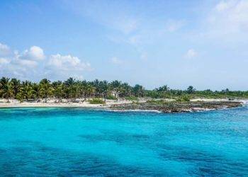 Cozumel Mexico beach view near Stingray Villa vacation rental with turquoise waters and lush palm trees.