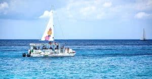 Colorful sailboat cruising in clear blue waters off Cozumel, Mexico, near Stingray Villa vacation rental. Perfect for relaxing marine adventures and exploring Caribbean beaches.