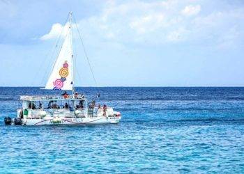 Colorful sailboat cruising in clear blue waters off Cozumel, Mexico, near Stingray Villa vacation rental. Perfect for relaxing marine adventures and exploring Caribbean beaches.