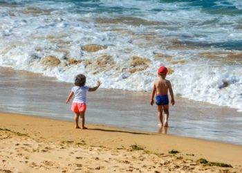 Kids playing on the sandy beach in Cozumel Mexico near Stingray Villa vacation rental. Family-friendly seaside retreat with clear waters, perfect for a tropical getaway.