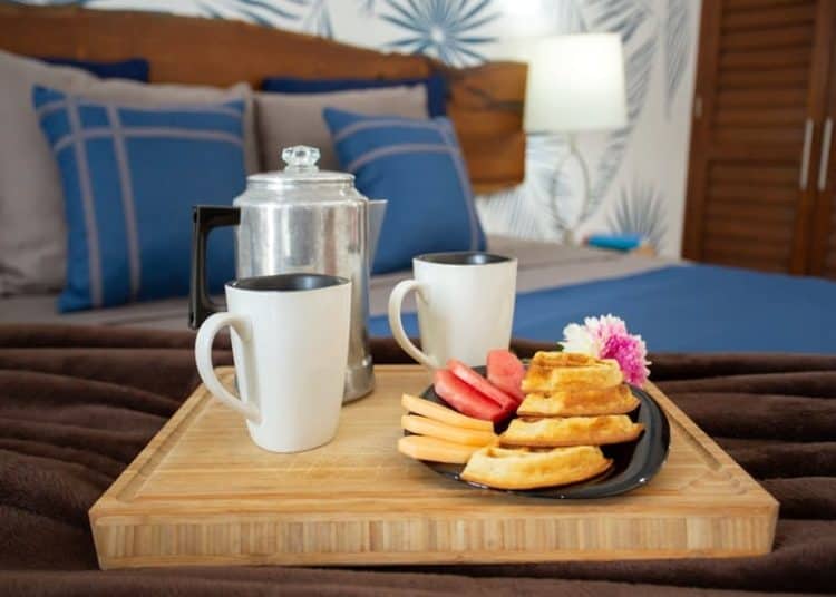Relaxing breakfast setup at Stingray Villa in Cozumel, Mexico, with coffee, fresh fruit, and snacks in a beautiful tropical-themed bedroom. Perfect for a seaside vacation.
