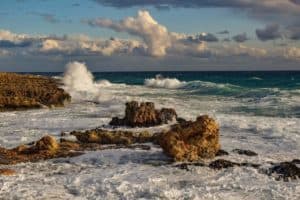 Rugged coastline of Cozumel Mexico with crashing ocean waves and rocky shoreline, offering scenic views perfect for a beach vacation near Stingray Villa.