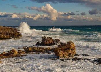 Rugged coastline of Cozumel Mexico with crashing ocean waves and rocky shoreline, offering scenic views perfect for a beach vacation near Stingray Villa.
