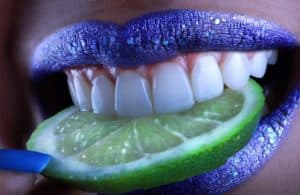 Cozumel Mexico vacation rental Stingray Villa vibrant blue lipstick with fresh lime slice in mouth, close-up of colorful makeup and tropical fruit