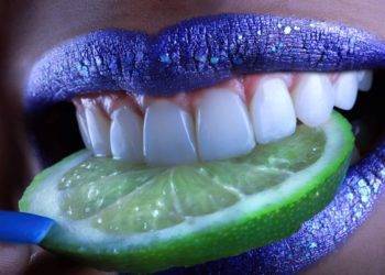 Cozumel Mexico vacation rental Stingray Villa vibrant blue lipstick with fresh lime slice in mouth, close-up of colorful makeup and tropical fruit
