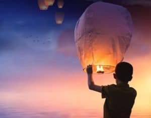 Colorful sky lantern floating over Cozumel Mexico during sunset at Cozumel Traditions for the New Year.