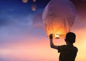 Colorful sky lantern floating over Cozumel Mexico during sunset at Cozumel Traditions for the New Year.