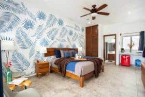 Stylish tropical-themed bedroom at Stingray Villa with wooden furniture and vibrant wall art.