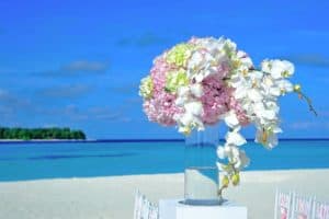 Colorful flower arrangement on a beachside table at Cozumel Mexico, perfect for a tropical vacation wedding or event backdrop.