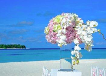 Colorful flower arrangement on a beachside table at Cozumel Mexico, perfect for a tropical vacation wedding or event backdrop.