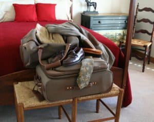 Luggage and travel accessories on a wooden bench in a cozy bedroom at Stingray Villa, Cozumel Mexico vacation rental.