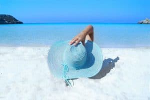 Bright turquoise straw hat on white sandy beach near Stingray Villa, Cozumel Mexico, overlooking clear blue Caribbean Sea, perfect for vacation relaxation and exploring the island.