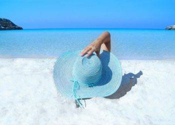 Bright turquoise straw hat on white sandy beach near Stingray Villa, Cozumel Mexico, overlooking clear blue Caribbean Sea, perfect for vacation relaxation and exploring the island.
