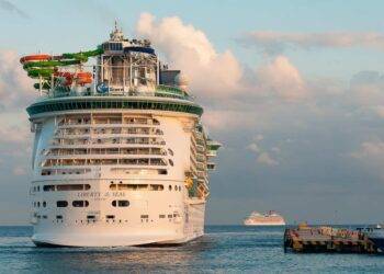 Luxury cruise ship Liberty of the Seas docked in Cozumel, Mexico, with vibrant water slides on deck, representing a perfect vacation destination.