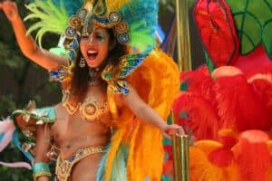Vibrant carnival performer in colorful costume with feathers during a parade in Cozumel Mexico, showcasing the lively cultural celebrations near Stingray Villa vacation rental.