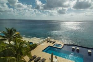 in Cozumel Mexico with oceanfront views, private pool, palm trees, and luxurious vacation rental accommodations. Perfect for a relaxing seaside getaway.