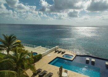 in Cozumel Mexico with oceanfront views, private pool, palm trees, and luxurious vacation rental accommodations. Perfect for a relaxing seaside getaway.