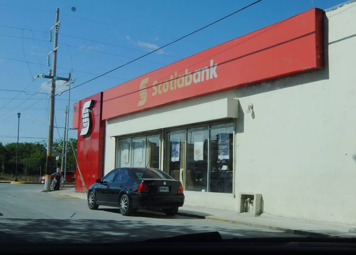 Scotiabank branch in Cozumel, Mexico, with a black car parked outside and clear blue sky. Perfect for travel guides and vacation rental descriptions on Cozumel island.