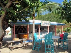 Soggy Dollar beach bar in Cozumel Mexico, featuring vibrant outdoor seating, tropical palm trees, and scenic mountain views, perfect for vacationers staying at Stingray Villa.