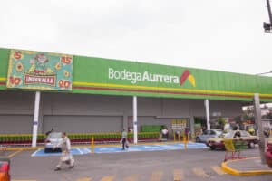 Brightly colored Bodega Aurrera supermarket exterior in Cozumel, Mexico, with shopping carts and customers, offering easy access for vacationers staying at Stingray Villa.