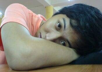 Sad woman resting her head on her arm at home or in a public space