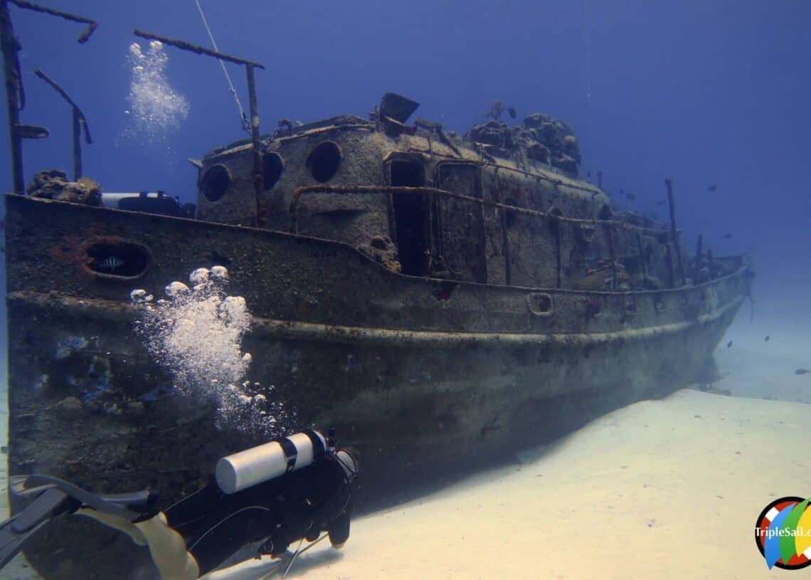 Wrecked ship underwater near Cozumel, Mexico, with scuba diver exploring the scenic ocean ruins.
