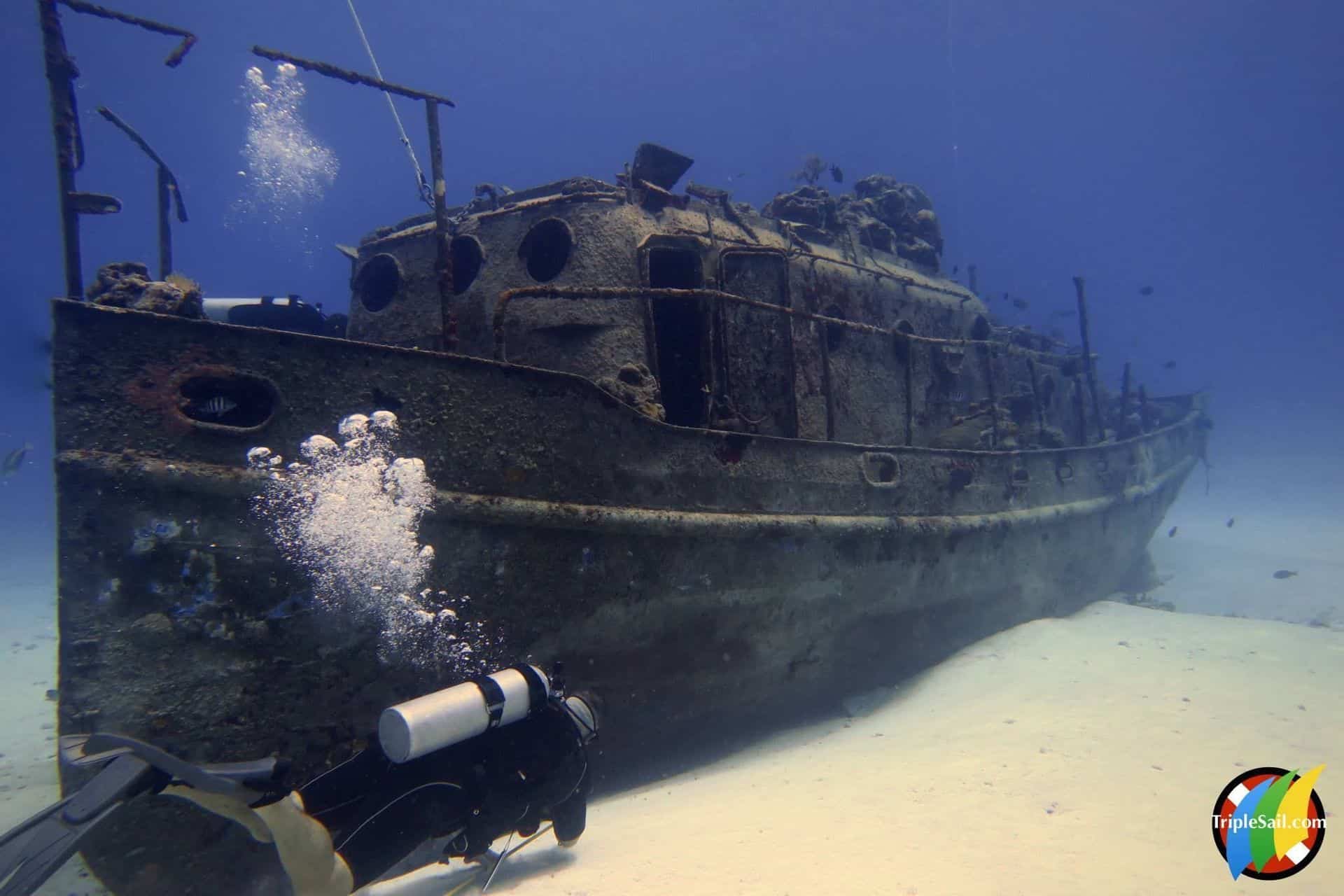 Wrecked ship underwater near Cozumel, Mexico, with scuba diver exploring the scenic ocean ruins.