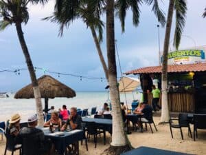 Beachside dining at Alberto’s Beach Bar in Cozumel, Mexico, with ocean views, tropical palm trees, and nearby beach bar. Perfect for relaxing vacation stays in this popular Caribbean island destination.