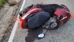 Motorcycle wreck on Cozumel Mexico street near Stingray Villa vacation rental, showing a red scooter with side mirror and dashboard, emphasizing travel safety and local transportation.