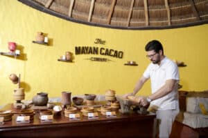 Handsome man preparing traditional Mayan cacao chocolate at Mayan Cacao Company, a popular attraction in Cozumel, Mexico, offering authentic Mayan cacao experiences and souvenirs.