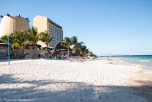 Cozumel Mexico beach view at Melia Resort, featuring white sand, turquoise waters, palm trees, and beachfront hotels. Perfect for relaxing oceanfront vacation in Cozumel.