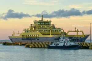 Large yellow ferry boat docked at the pier during sunset in Cozumel, Mexico