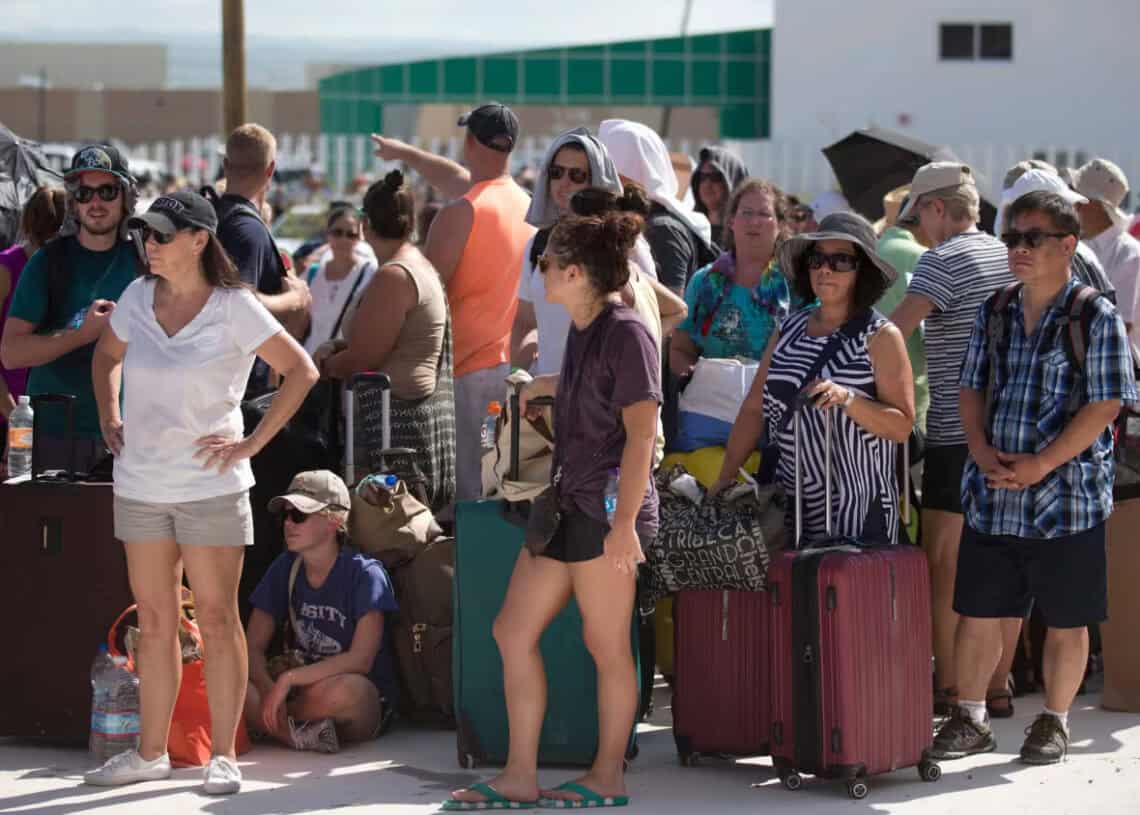 busy airport crowd with luggage and travelers waiting in line at Cozumel evacuating hurricane