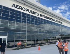 Modern Tulum International Airport with glass facade and staff in safety vests.