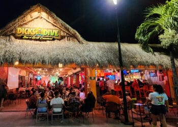 Dicks Dive Bar & Grill at night with lively crowd and tropical decor