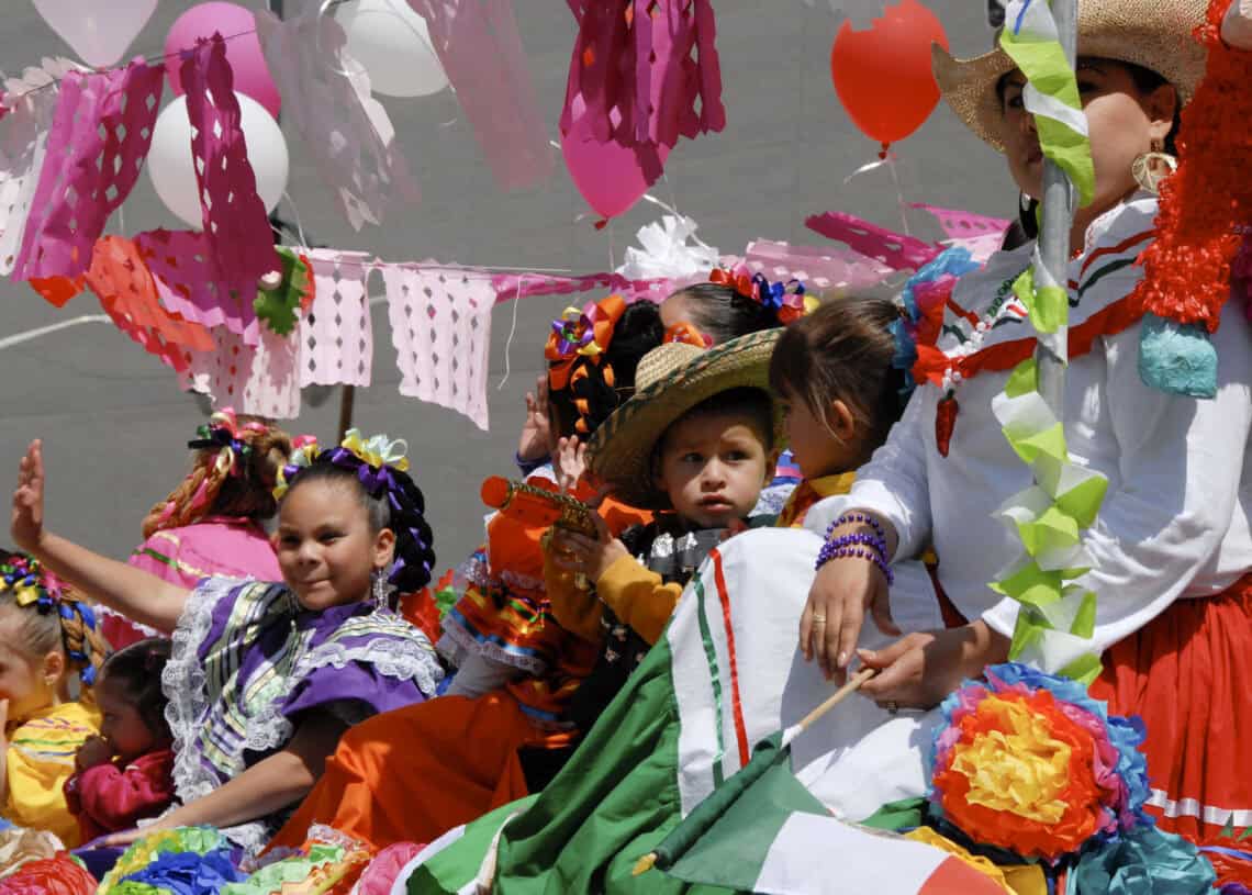 Colorful Mexican children celebrating Denver's cinco de Mayo with traditional costumes and vibrant decorations.