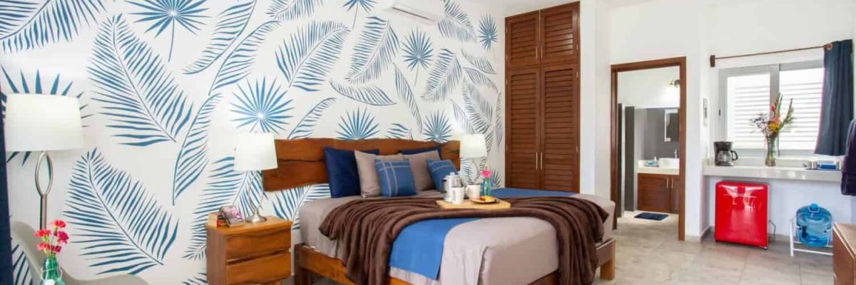 Stylish tropical-themed bedroom at Stingray Villa with wooden furniture and vibrant wall art.