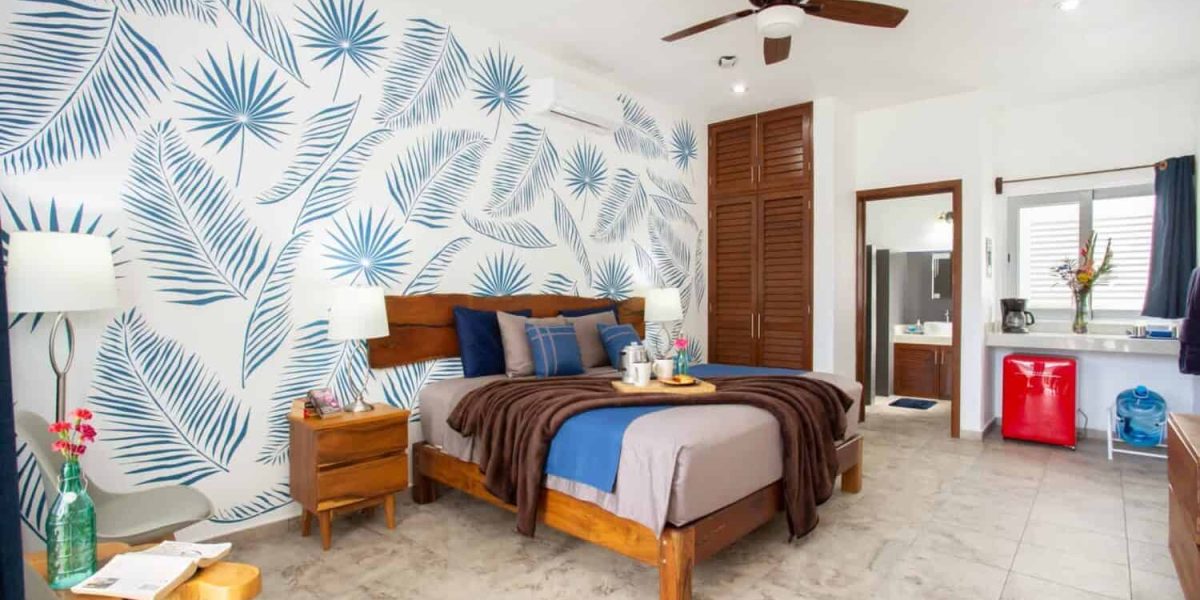 Stylish tropical-themed bedroom at Stingray Villa with wooden furniture and vibrant wall art.